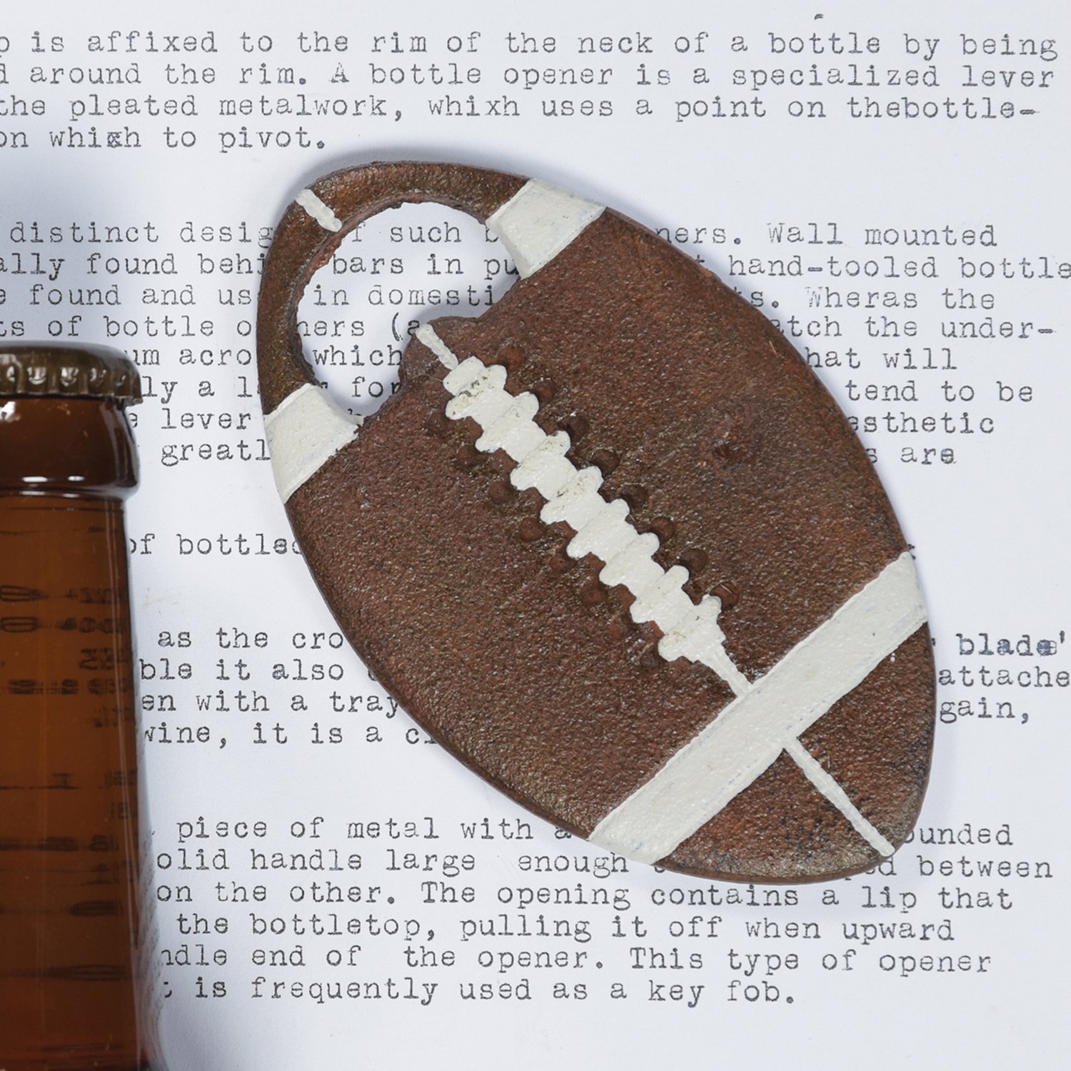 Football Bottle Opener on a typed page with a part of a bottle neck showing